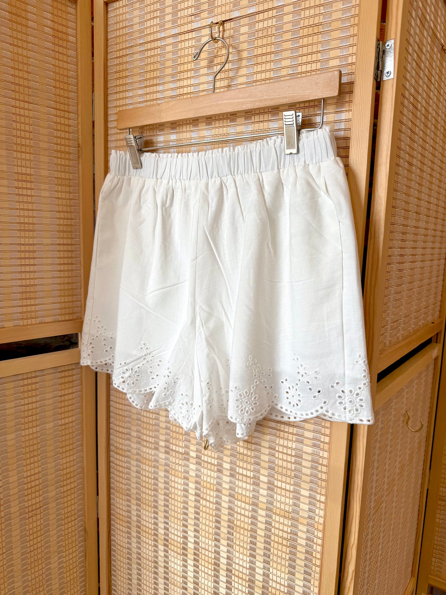 White tailored shorts with scalloped edge.