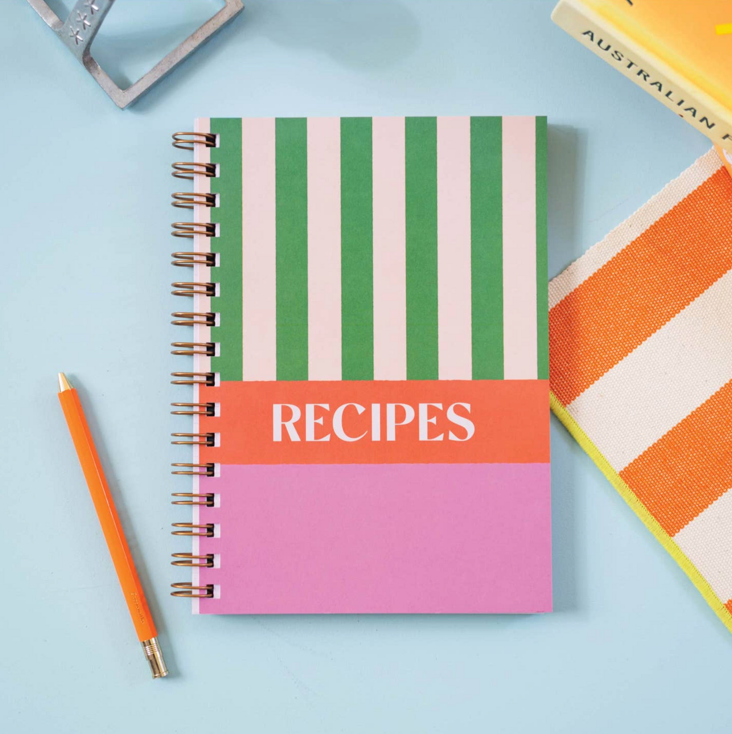 Recipe notebook with striped cover on a light blue background