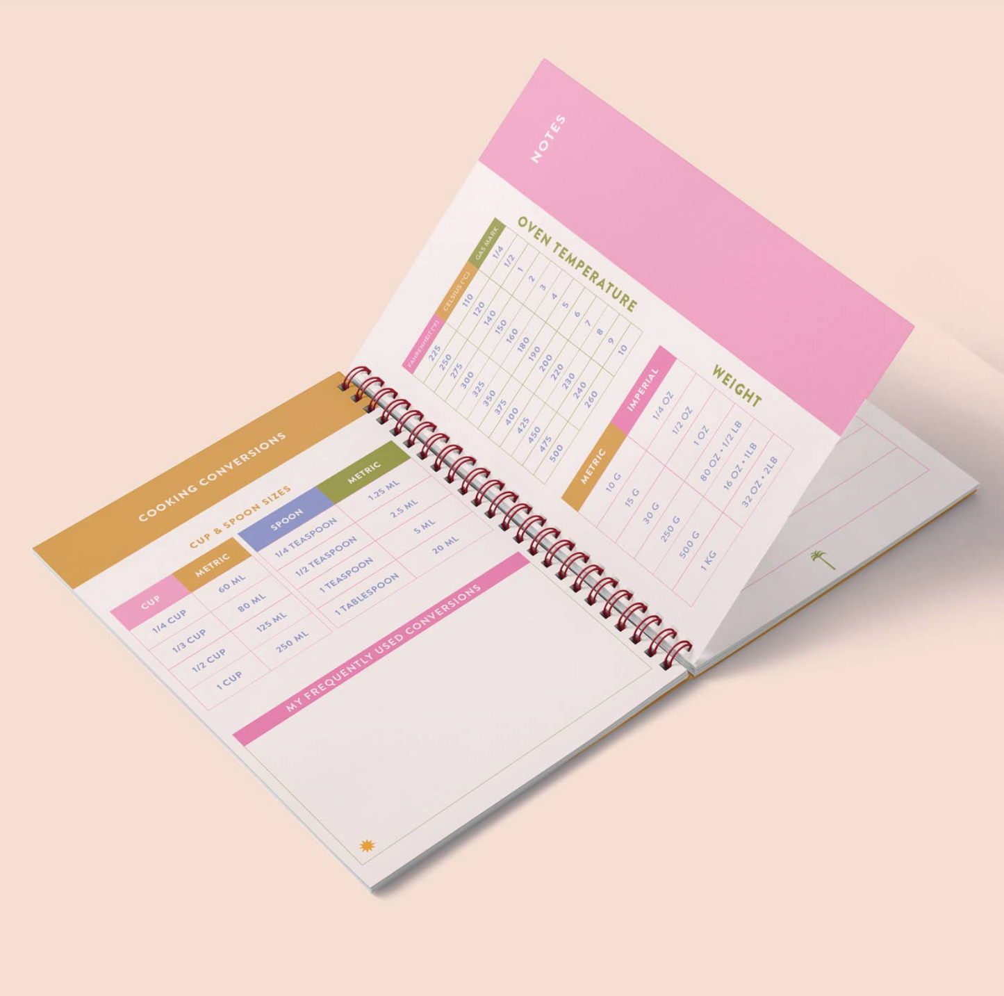 Open spiral-bound planner with colorful sections on a beige background