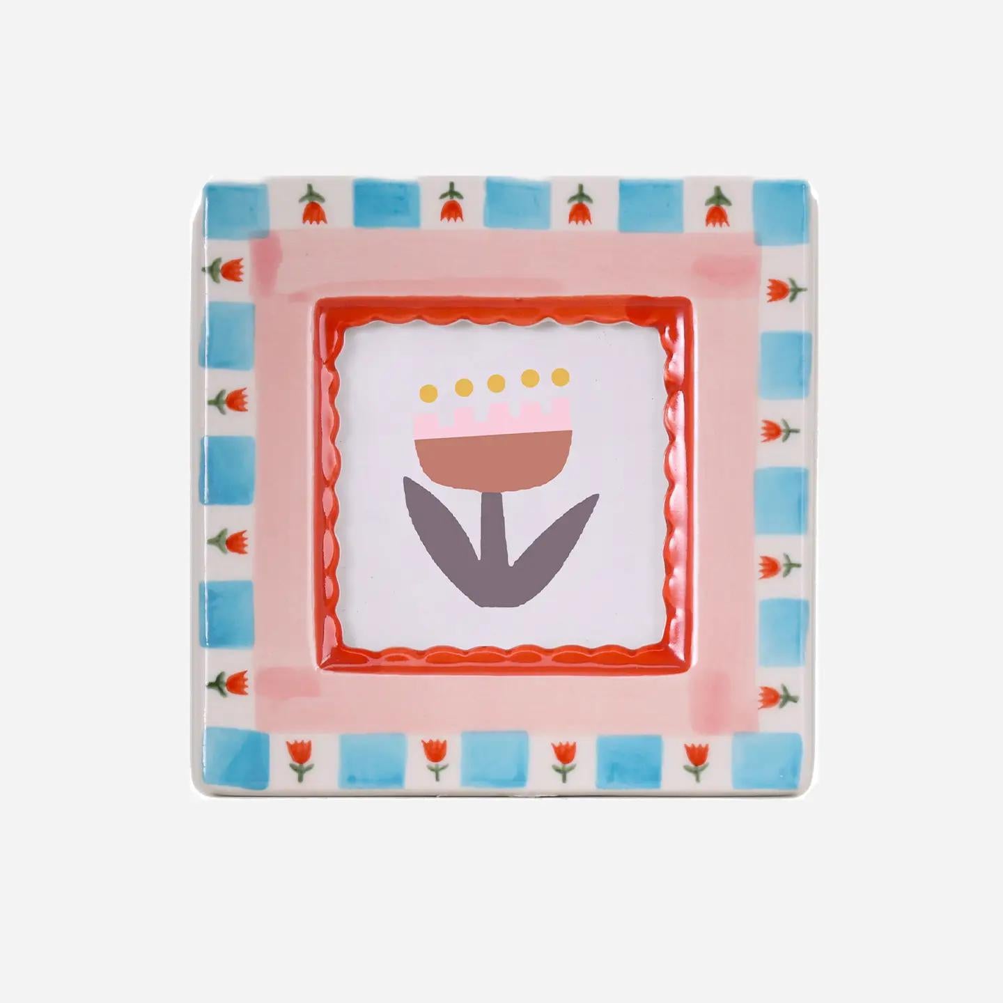 “Hand-painted ceramic photo frame with red flower patterns on a white base.”
“Close-up of a red floral ceramic frame holding a small photograph on a wooden table.”
“Decorative red flower photo frame surrounded by petals and soft light.”