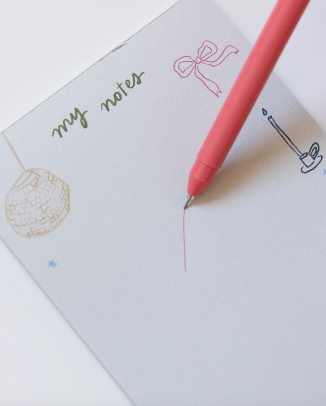Notebook with 'my notes' text and doodles, featuring a pink pen.