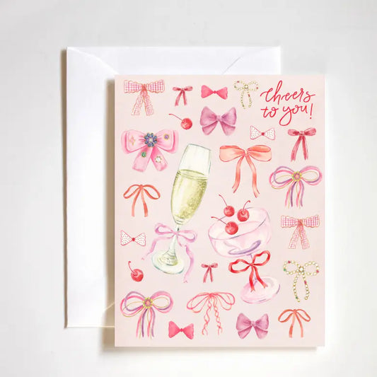 "Coquette Cheers Card" – Feminine A2 congratulations card with hand-drawn bows and luxe finish

"Bows & Congrats Card" – Girly celebration card featuring coquette-style artwork

"Cheers to You Stationery" – Playful and elegant card perfect for congratulating with style