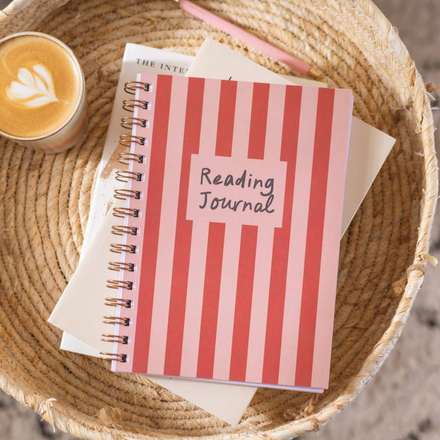 Striped reading journal with a cup of coffee on a woven surface