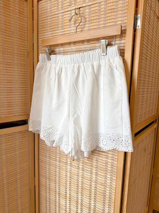 White tailored shorts with scalloped edge.
