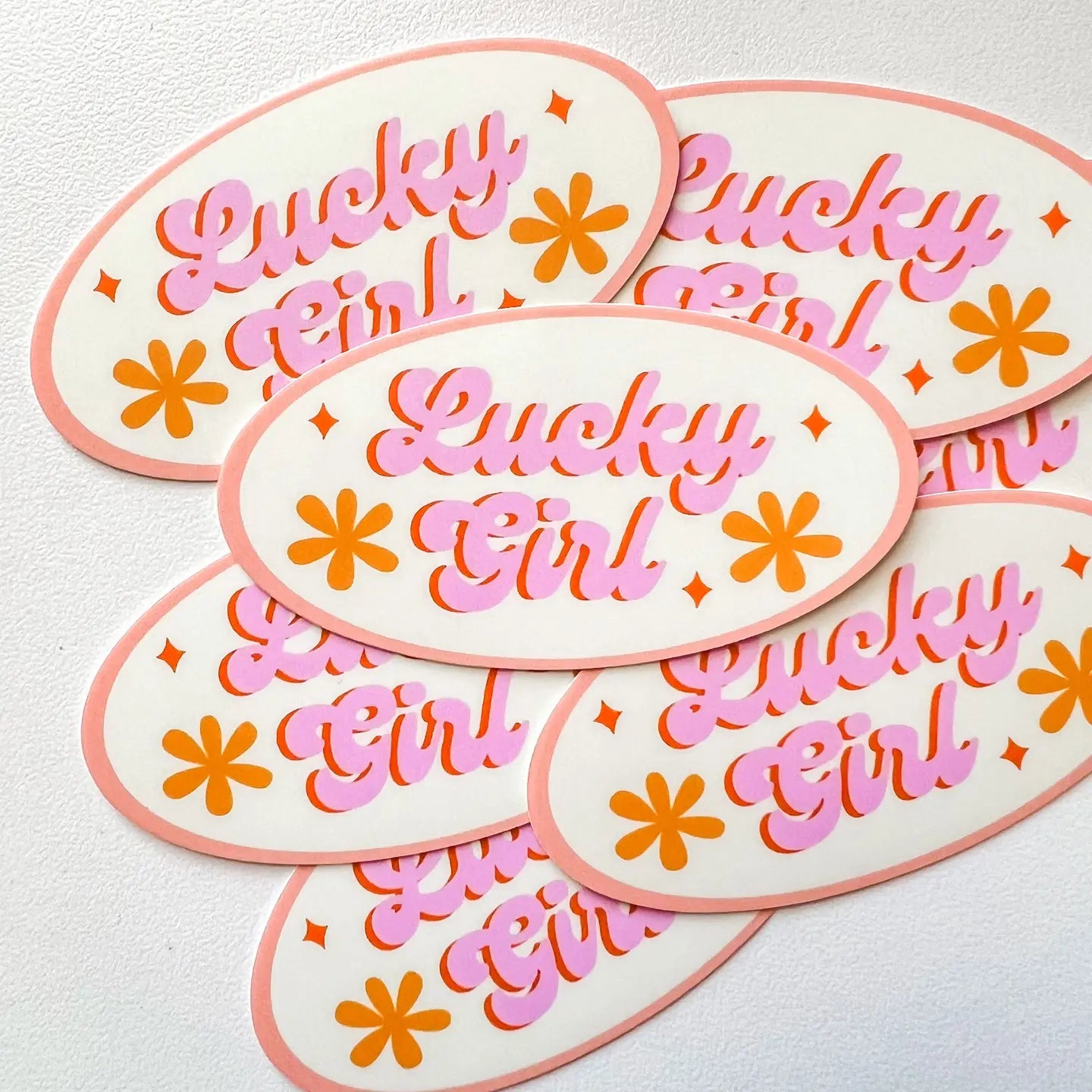 “Lucky Charm” – Close-up of the “Lucky Girl Syndrome 2023” sticker with matte finish

“Manifest Magic” – Sticker on a pastel water bottle surrounded by crystals and cozy vibes

“Good Vibes Only” – Sticker on a laptop with soft sunlight and floral accents