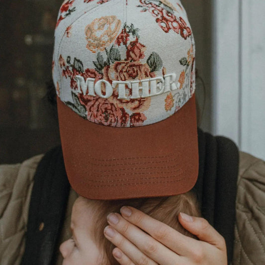 “Embroidered Floral Mother Hat” – Hat on a rustic wood table with flowers and sunglasses

“Maroon Bill Mother Hat” – Close-up of embroidery and floral pattern with soft natural lighting