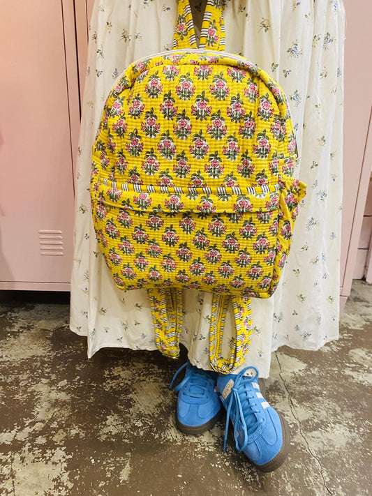 “Quilted Floral Sage Backpack” – Backpack styled on a wooden bench with flowers spilling out

“Pink Floral Backpack Flat Lay” – Laid out with books, sunglasses, and everyday essentials