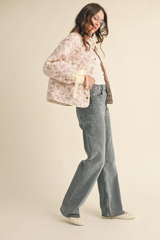 “Cottagecore Cozy” – Model walking outdoors in floral quilted jacket with ribbons tied

“Ribbon Ready” – Close-up of cuff ribbon detail and floral quilting

“Bloom & Button Up” – Front view of the jacket buttoned up with collar popped