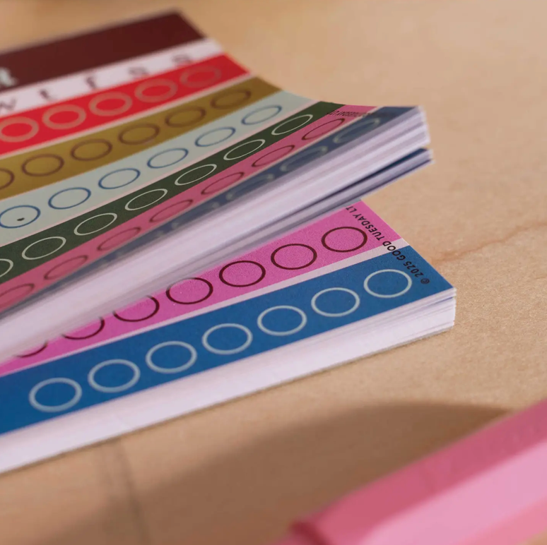 Colorful label sheets with circular patterns on a beige surface