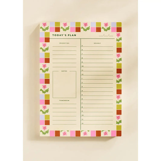 “Floral Checkered Planner Pad” – Close-up of floral-bordered daily planner with pen and coffee mug

“Pretty & Productive Desk Setup” – Notepad styled on a workspace with colorful stationery
